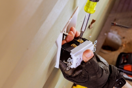 Electrician installing a GFCI outlet in a Boca Raton home